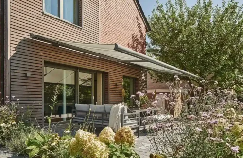 Moderne Terrasse mit Sonnenmarkise und üppiger Bepflanzung