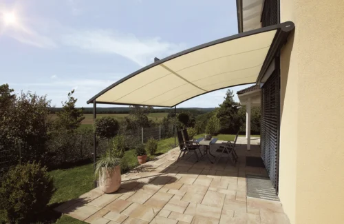 Moderne Terrassenüberdachung mit stilvollen Möbeln bei Sonnenschein